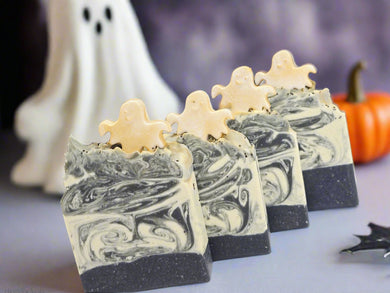 Halloween-themed soap bars with ghost decorations in front of a 'Sweet Haunted Home' sign.