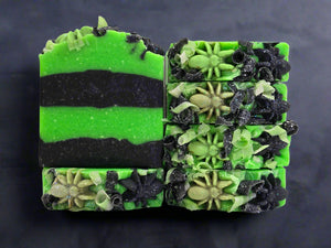 Two green and black soap bars with decorative elements on a white background