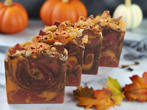 Three layered soap bars with a decorative top on a white background
